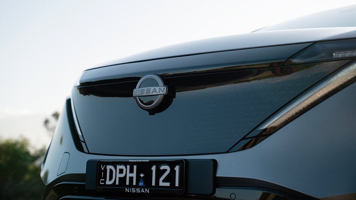 Large solid black grille on grey Nissan Ariya Advance+ SUV.