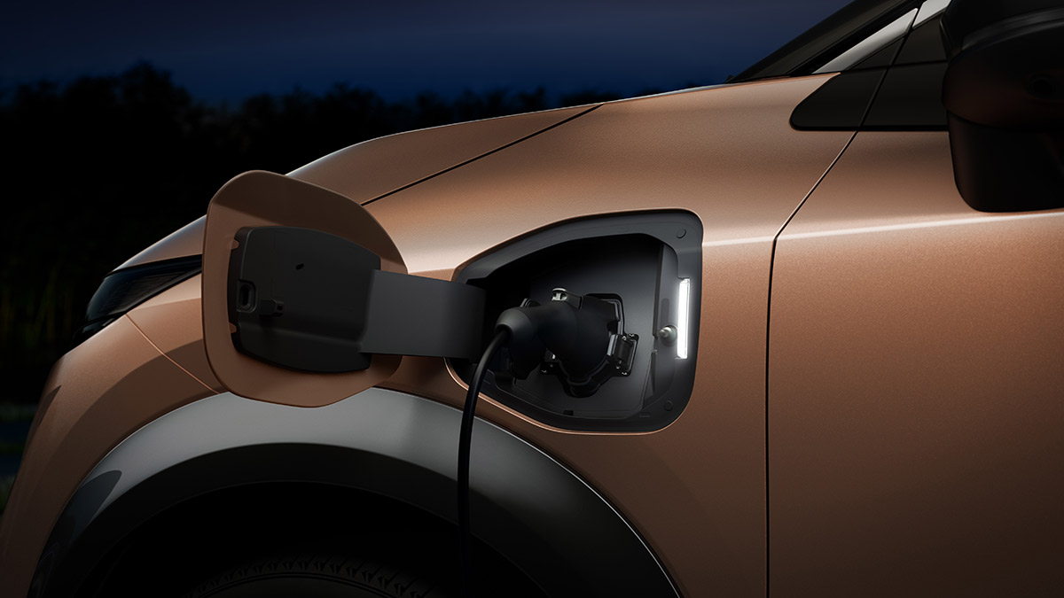 Charging flap open for copper-coloured Nissan Ariya medium electric SUV