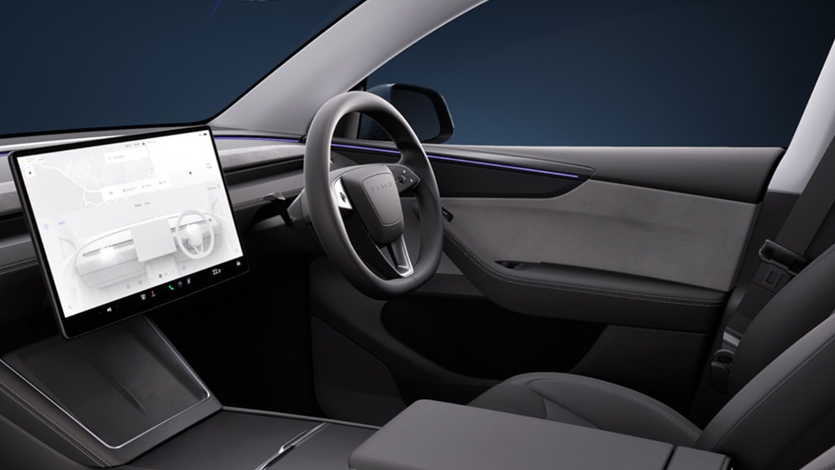 Large centre touchscreen and steering wheel in minimalist cockpit of Tesla Model Y electric SUV