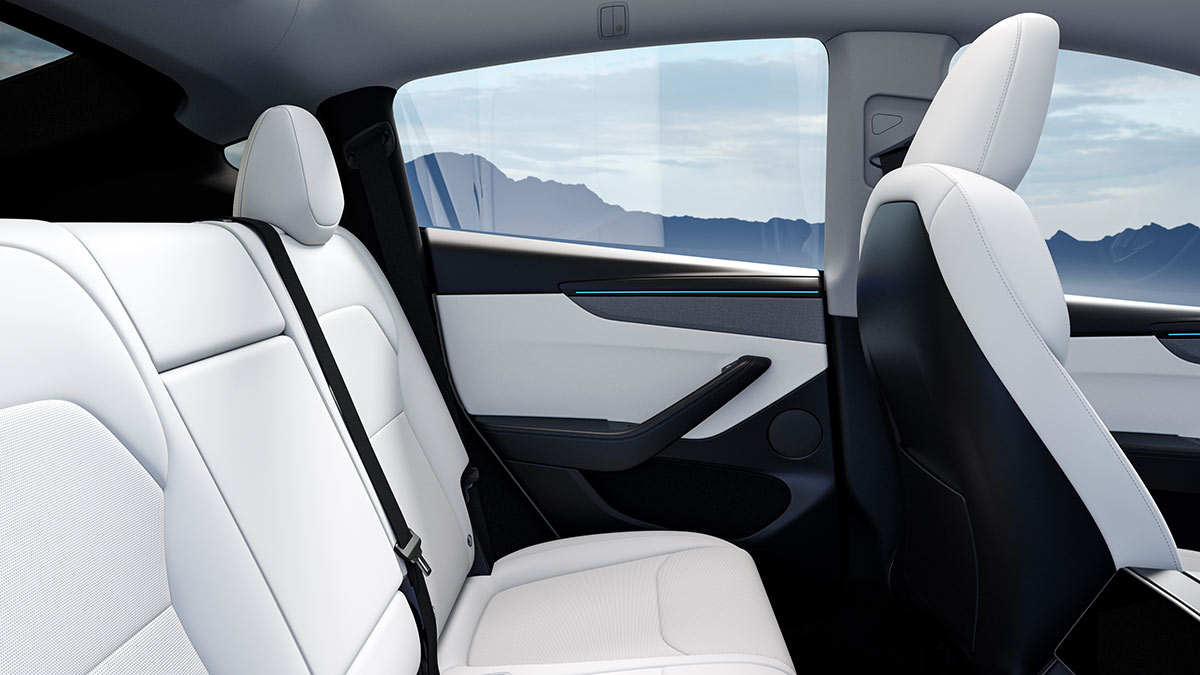 Rear seat area in Tesla Model Y SUV with white seat upholstery and door trim 
