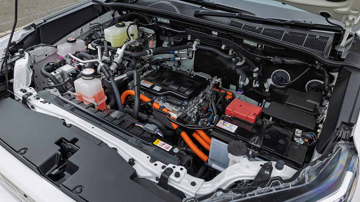 Bonnet up on white Toyota HiLux BEV showing electric powertrain taking up entire engine bay.