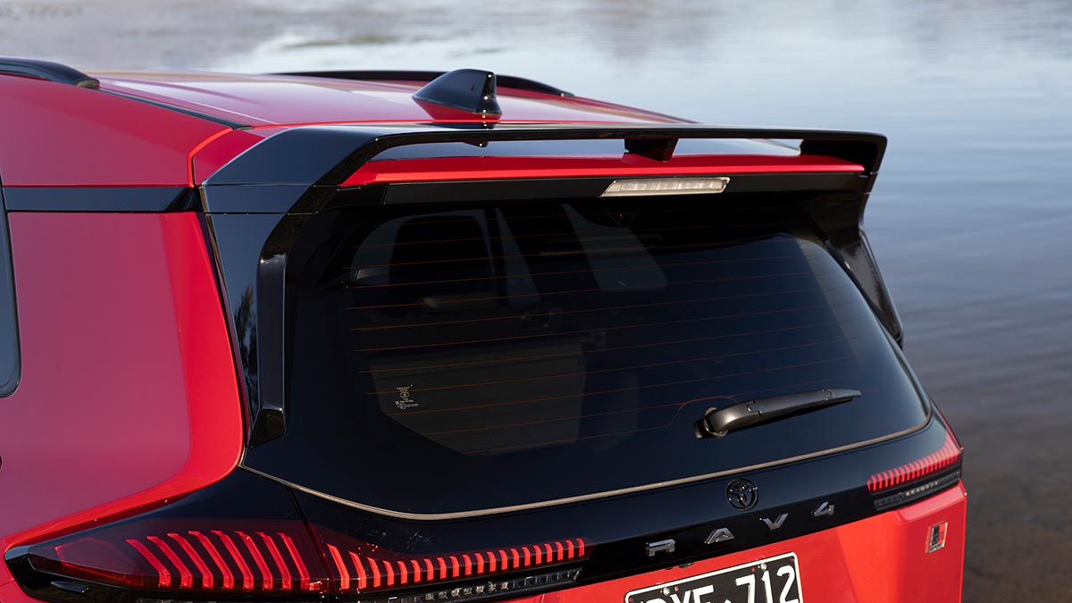Prominent black high-mounted rear spoiler at rear of red Toyota RAV4 GR Sport medium SUV.