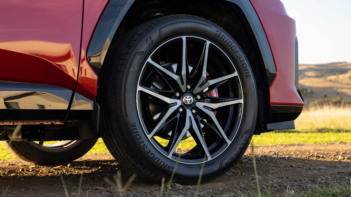 Black 20-inch alloy wheel with low-profile tyre and red brake calliper at rear of red Toyota RAV4 GR Sport.
