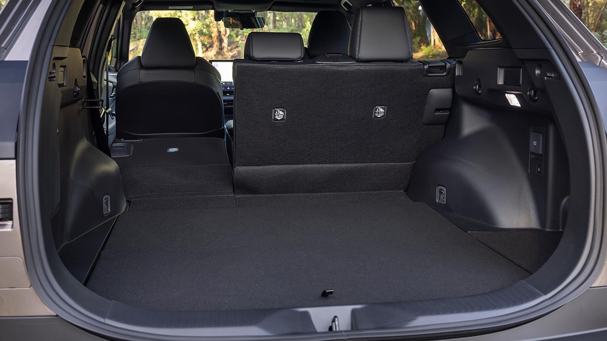 Cargo area in Toyota bZ4X Touring SUV with smaller portion of split-fold rear seatback folded down.