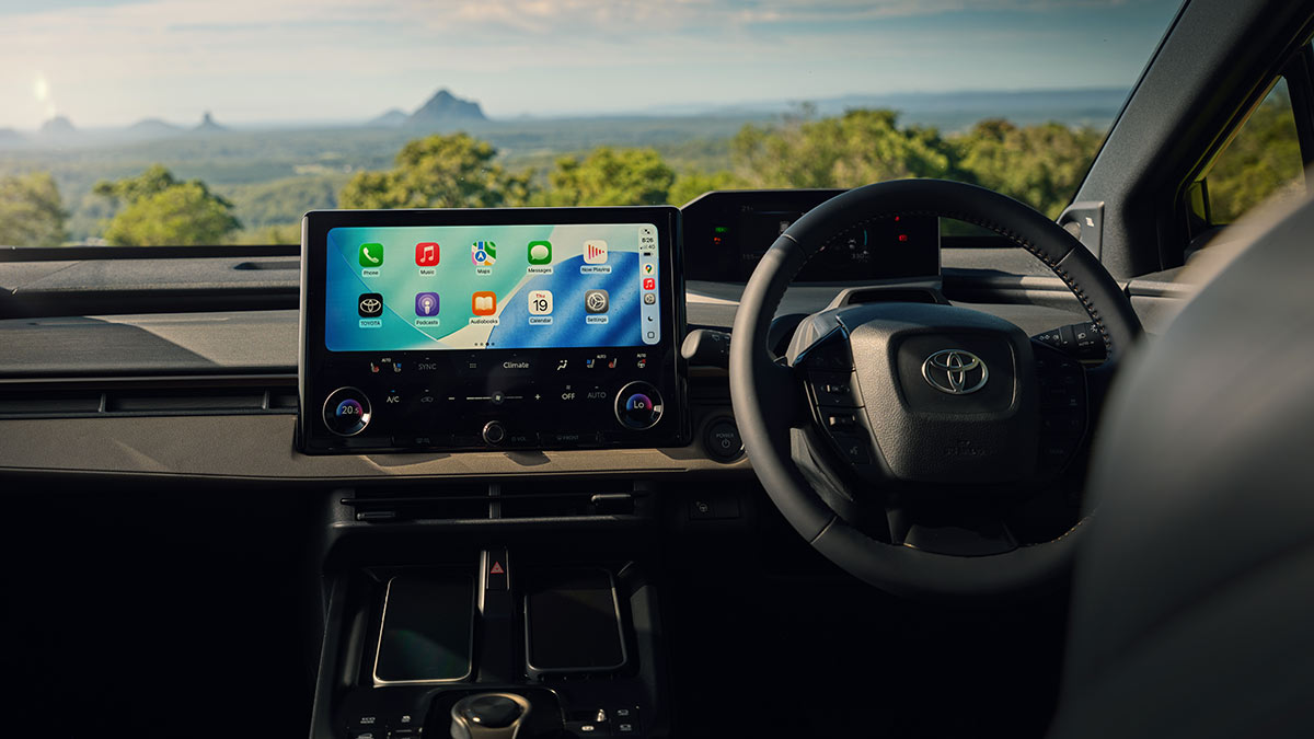 View of Toyota bZ4X Touring SUV dashboard from rear seats, showing large central screen.