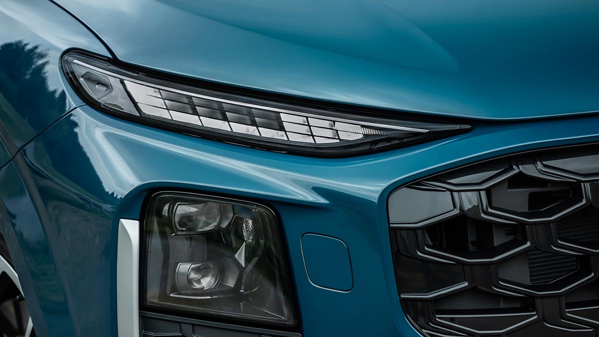 Detail shot of high-tech digital matrix LED headlights on blue metallic Audi Q3 small SUV.