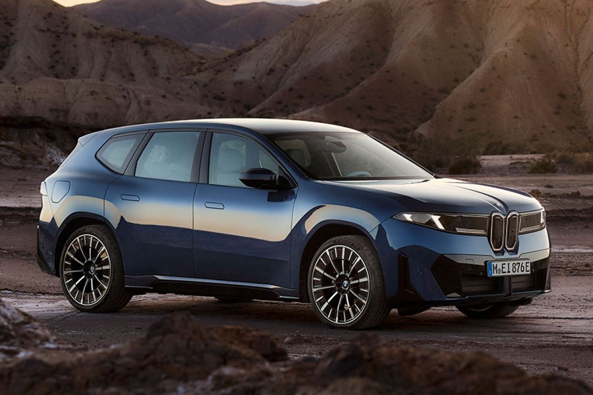 Blue BMW iX3 electric medium SUV in remote rocky mountainous location.