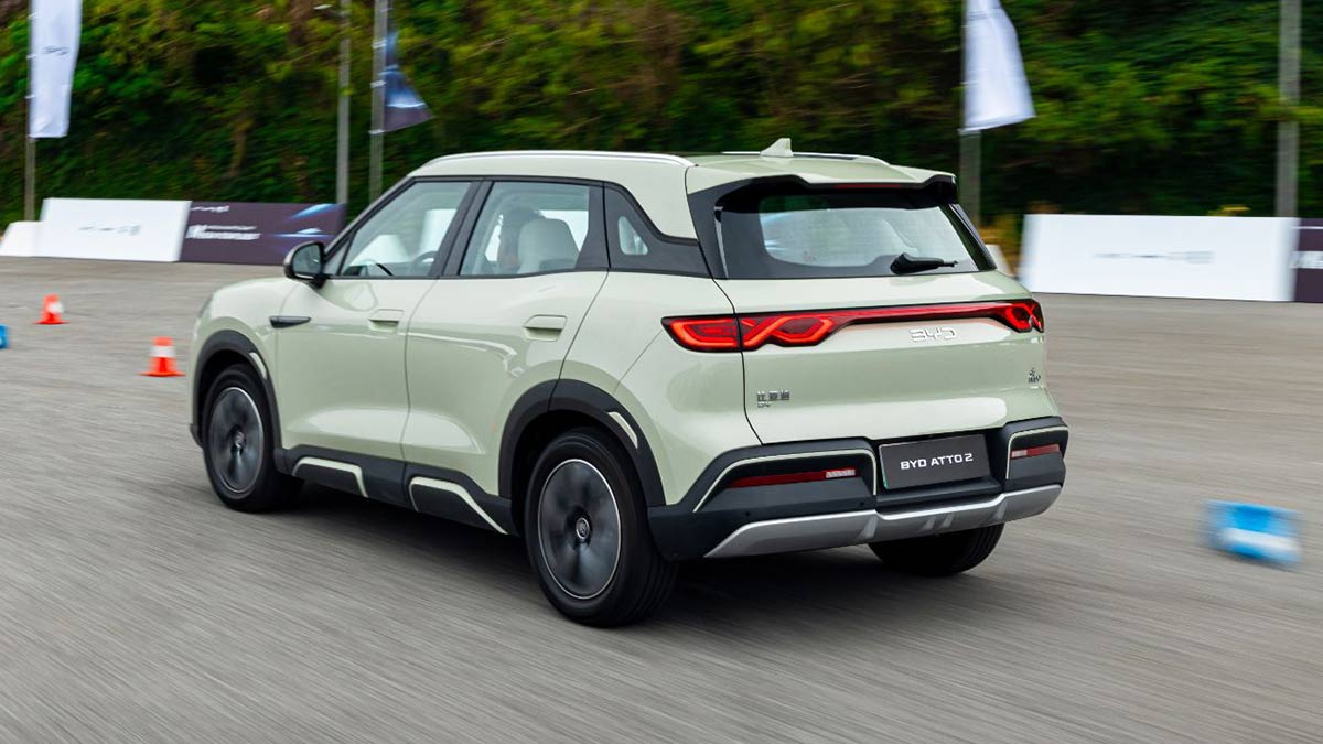 Rear view of light green BYD Atto 2 small electric SUV driving on enclosed test track in China 