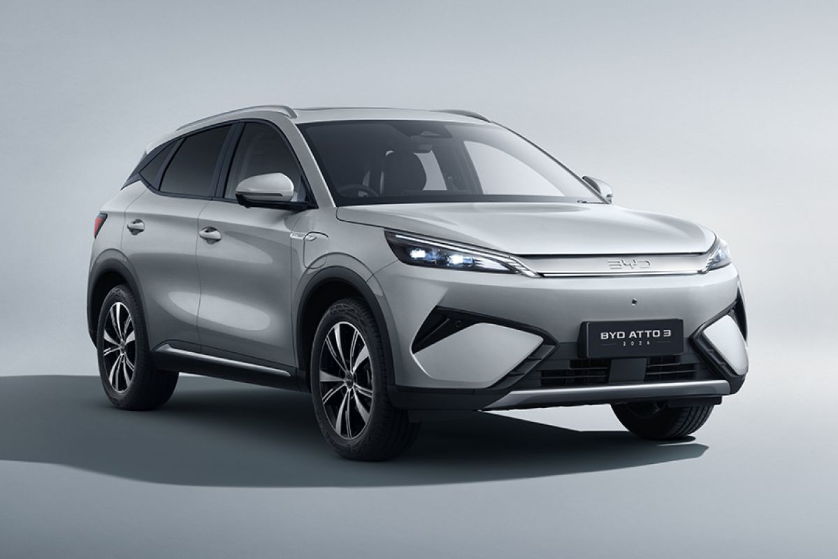 Frontal studio image of white BYD Atto 3 electric SUV with redesigned fascia including LED light strip across car.