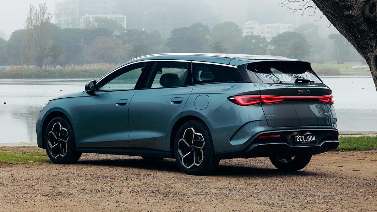 Rear view of sage green BYD Seal 6 Touring wagon parked at Albert Park Lake with misty Melbourne CBD skyline behind.