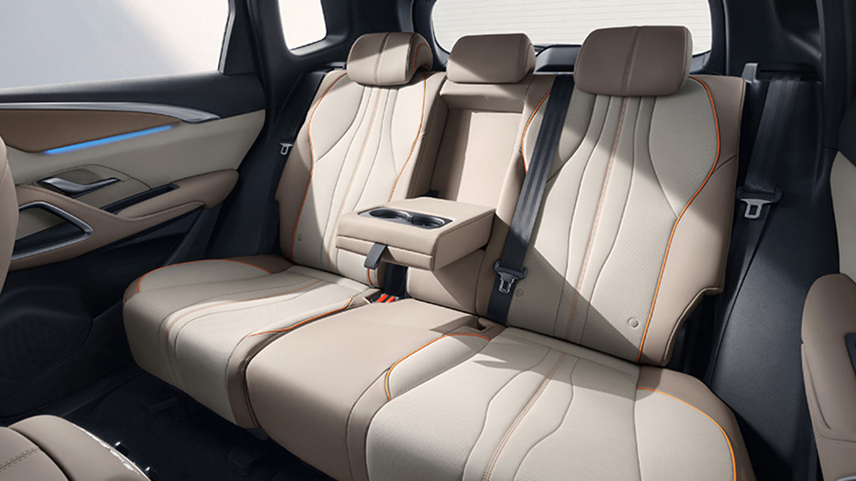Rear seat area in BYD Sealion 5 SUV with centre pull-down armrest and two-tone cream and brown trim.