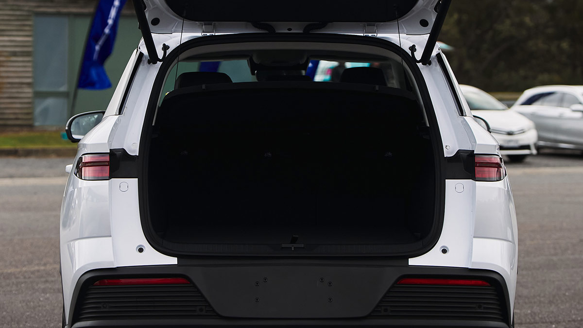 Rear view of white BYD Sealion 5 SUV with tailgate open, showing dark-trimmed cargo area. 