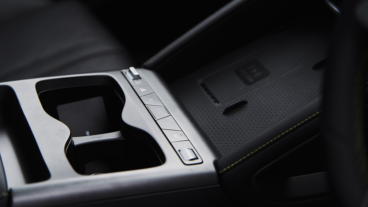 Centre console in BYD Sealion 5 SUV with cupholders, switchgear, metallic-look trim and phone charging pad.