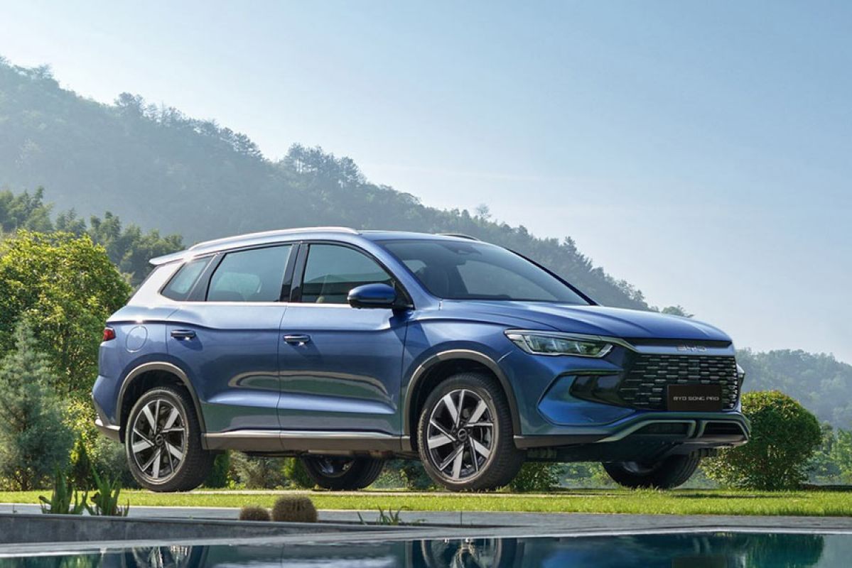 Blue BYD Sealion 5 medium SUV parked on lawn at property in mountainous region with pool in foreground.