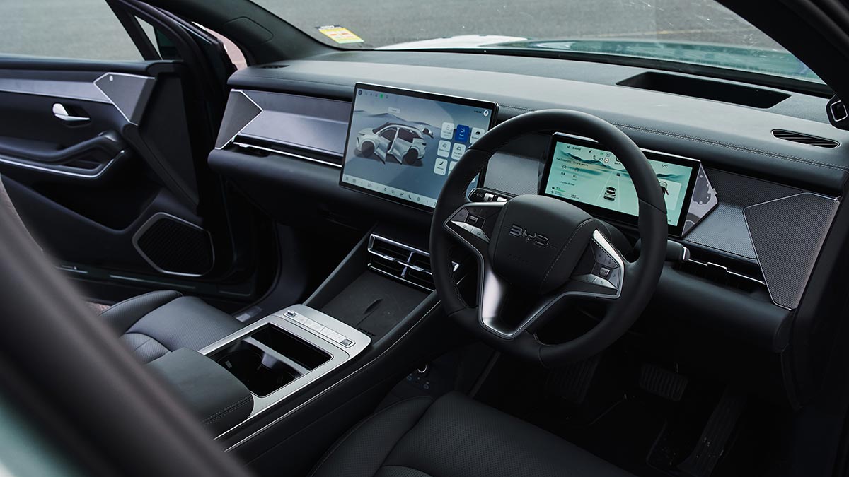 View into cockpit of BYD Sealion 8 SUV from front door showing dual digital screens and dark trim with chrome highlights.