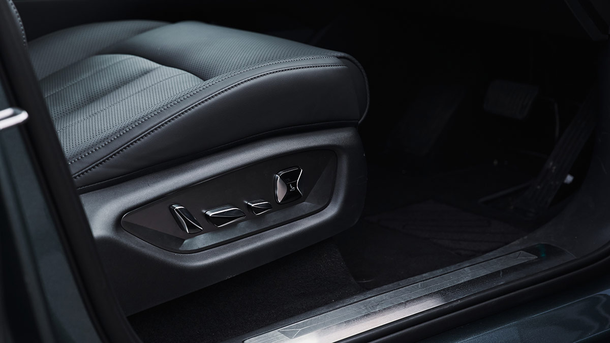 Detail shot of driver’s seat in BYD Sealion 8 SUV with leather trim and upmarket chrome controls for seat adjustment. 