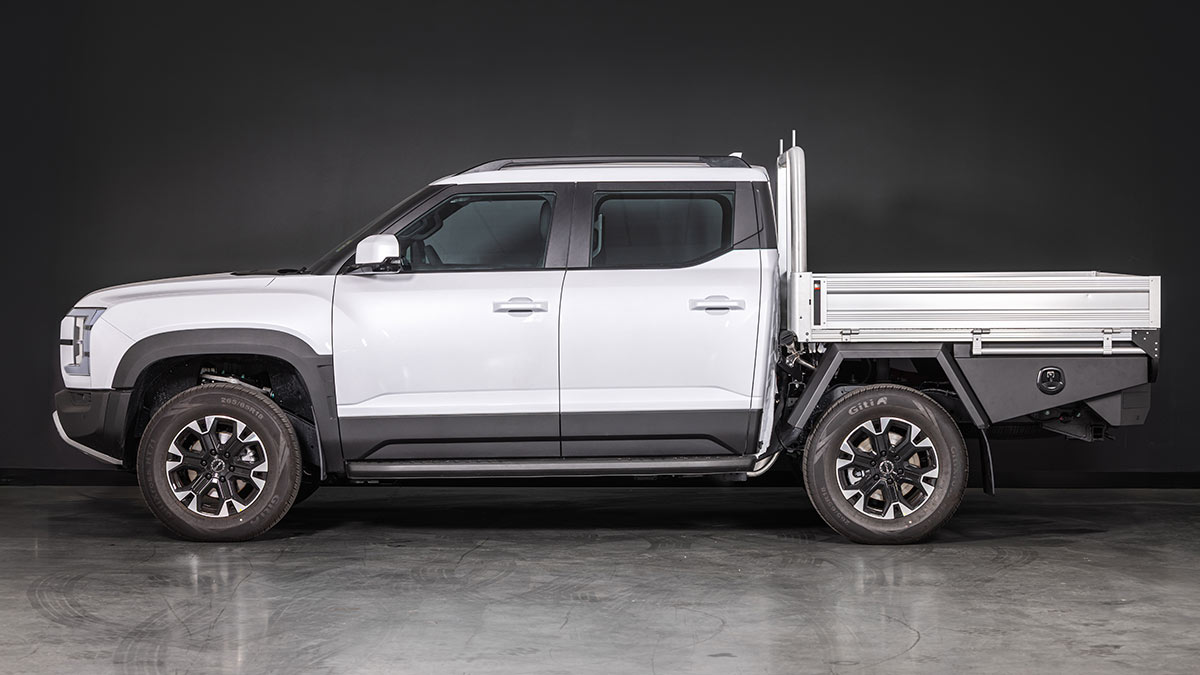 Studio shot showing side-one view of white BYD Shark 6 Cab-Chassis dual-cab ute fitted with optional alloy tray.
