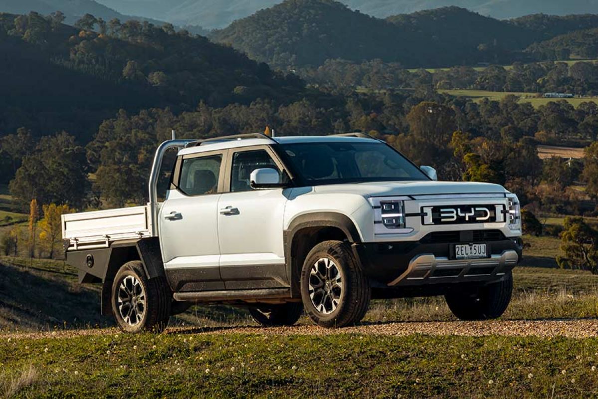 White BYD Shark 6 Dynamic Cab Chassis dual cab ute on gravel track on hilly rural property.
