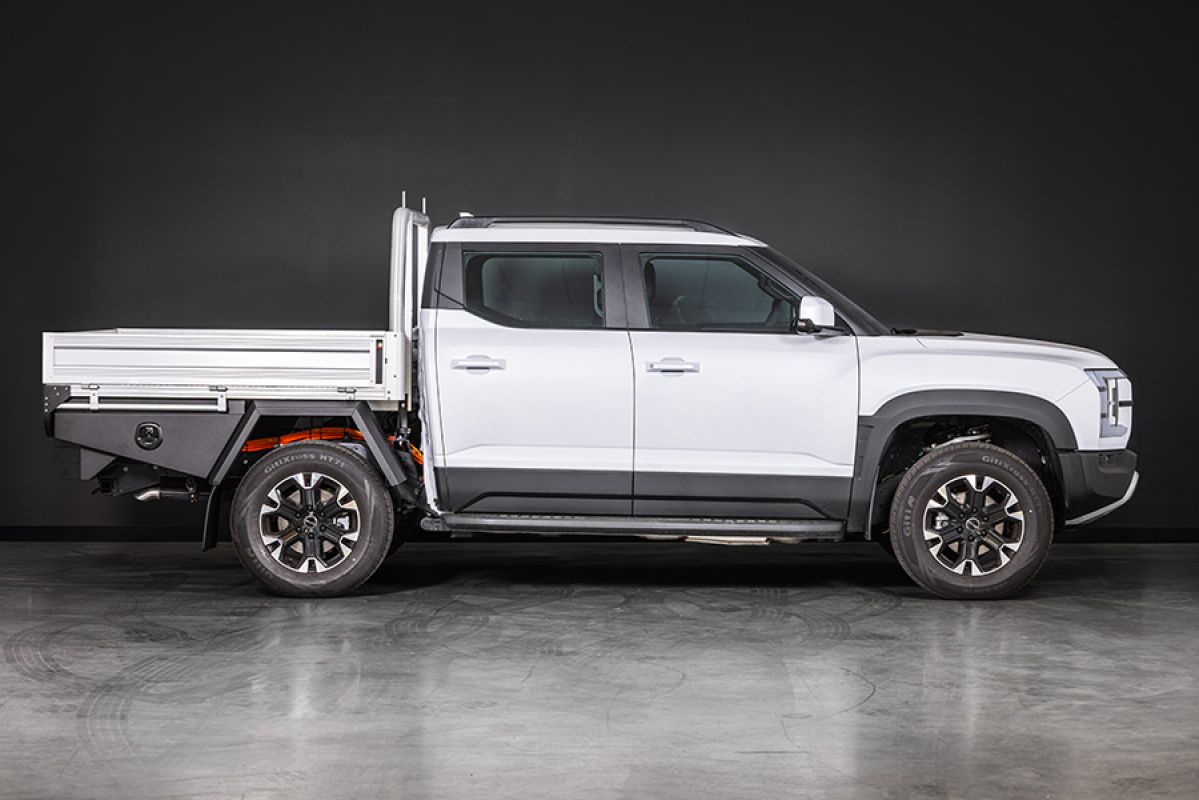 Studio shot showing side-one view of white BYD Shark 6 Cab-Chassis dual-cab ute fitted with optional alloy tray.
