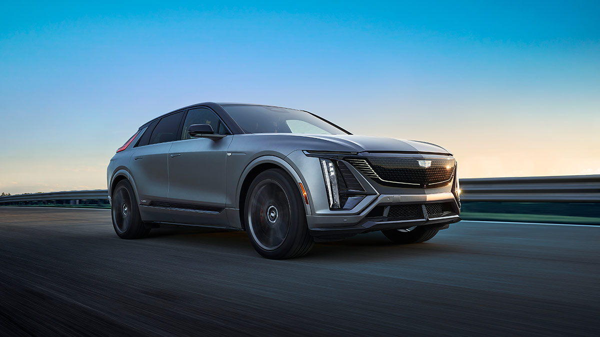 Silver Cadillac Lyriq-V performance SUV on the road at dusk with armco in background