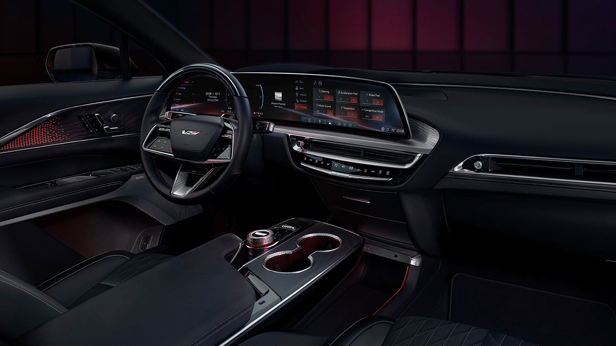 Dark interior of Cadillac Lyriq-V SUV with sporty red highlights on dash, centre console and door trim