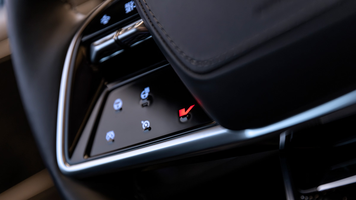 Close-up shot of Cadillac Lyriq-V's steering wheel showing red V-Mode button