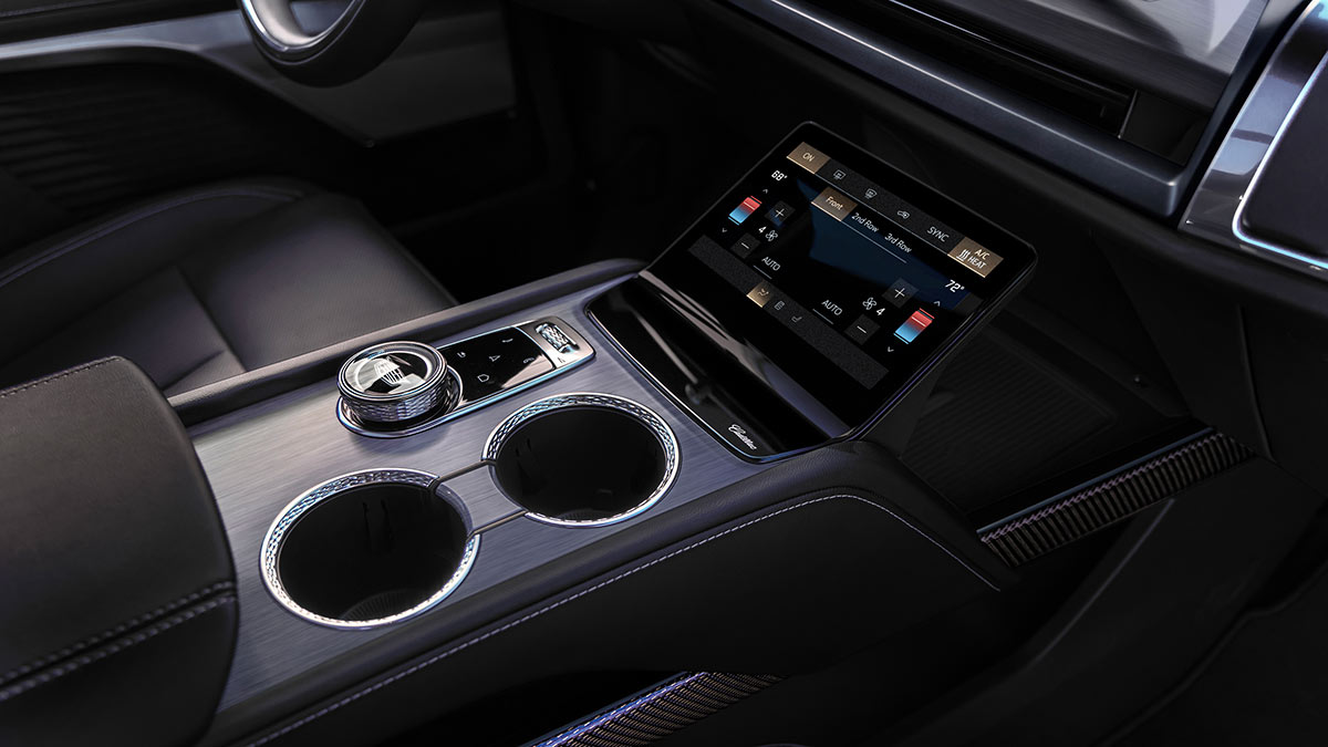 Centre console of Cadillac Vistiq SUV showing cup holders, drive controller and display for five-zone climate control system