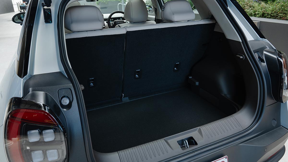 Cargo area inside silver GAC Aion UT electric hatchback with 60/40 split-fold rear seats upright.
