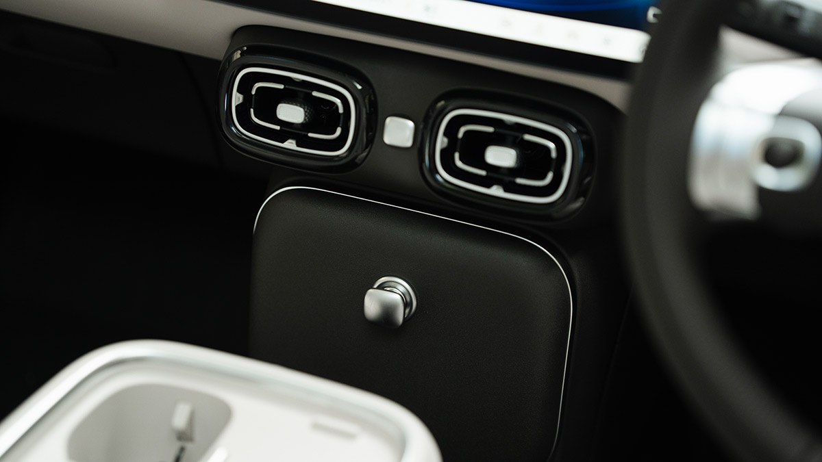 Lower dash area in GAC Aion UT electric hatch showing stylish air vents and lidded storage area with large silver knob.