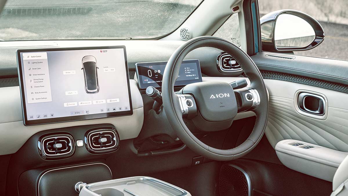 GAC Aion UT driver's cockpit area with two-tone dark/cream trim and twin screens on dash.