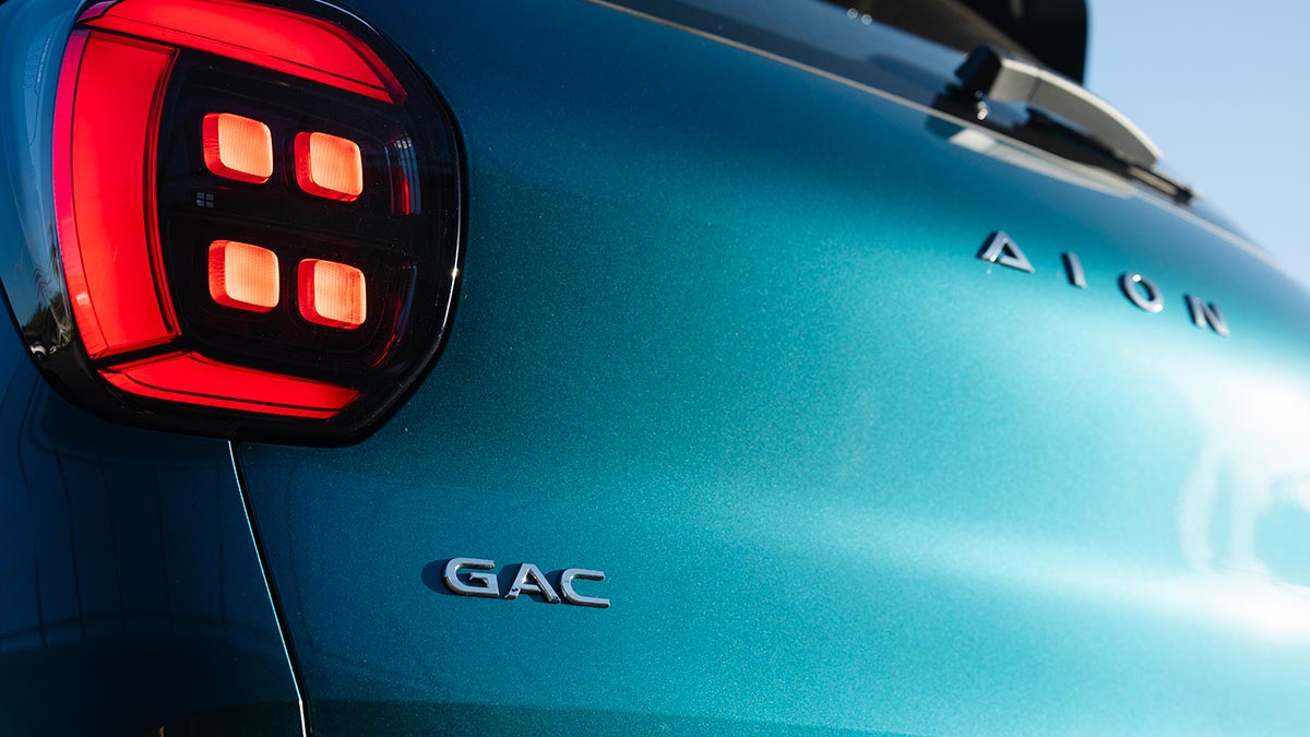 Close-up of green GAC Aion UT EV's C-shaped LED tail-light design with pixel light graphic.