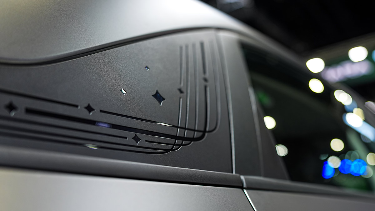 Close-up of rear exterior pillar trim on Geely EX2 city EV with stars and dynamic line graphics.