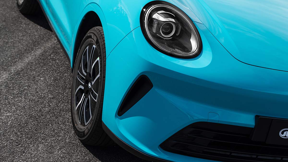 Detail image of GWM Ora 5 small SUV front end with round headlight, 18-inch machined alloy wheel and large air vents.