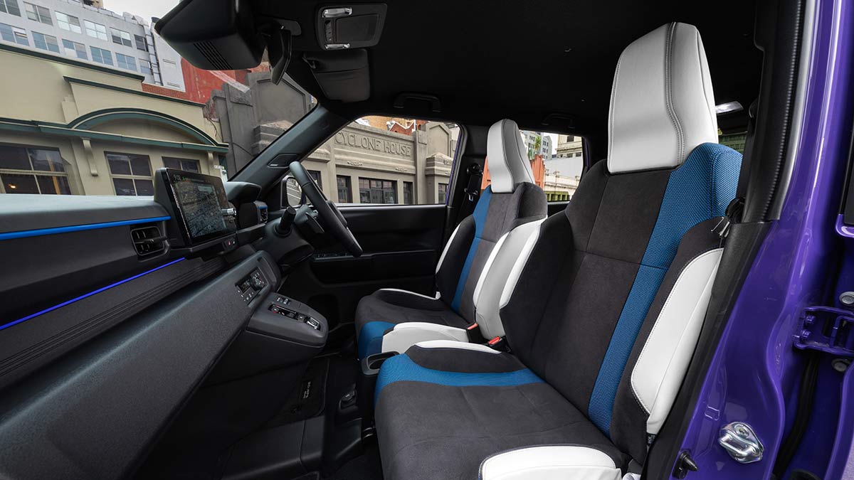 Front compartment of Honda Super-One EV with heavily bolstered seats with grey cloth and blue and light-coloured inserts.