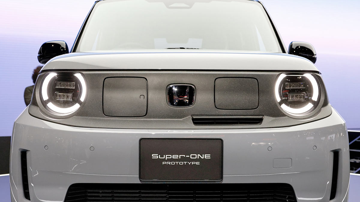 Front end of Honda Super-One EV with circular LED headlights, two EV charging ports and large front camera.