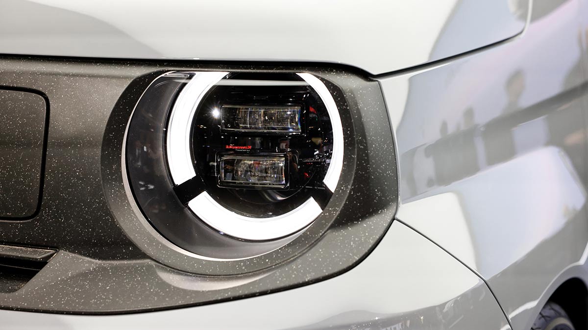 Close-up of Honda Super-One EV’s headlight with circular LED daytime running light and indicator.