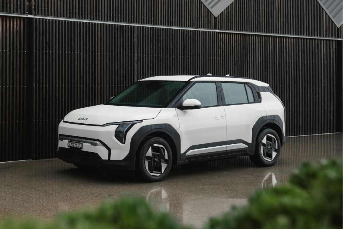 White Kia Sportage SX Hybrid SUV parked on street in urban industrial area