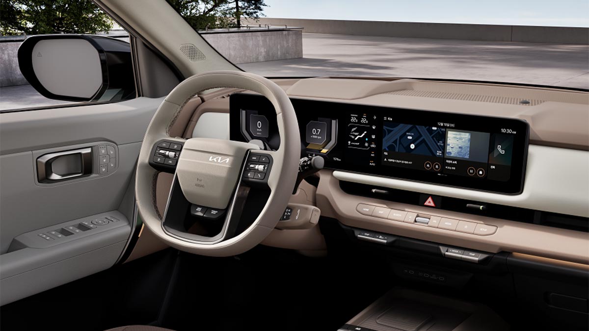 Steering wheel and dual digital screens in Kia Seltos SUV with two-tone cream/flesh-coloured trim. 
