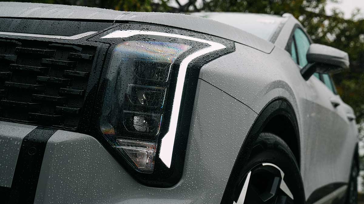 Front-end close-up of Kia Sportage SX Hybrid showing new vertical headlight cluster and wrap-around daytime running light