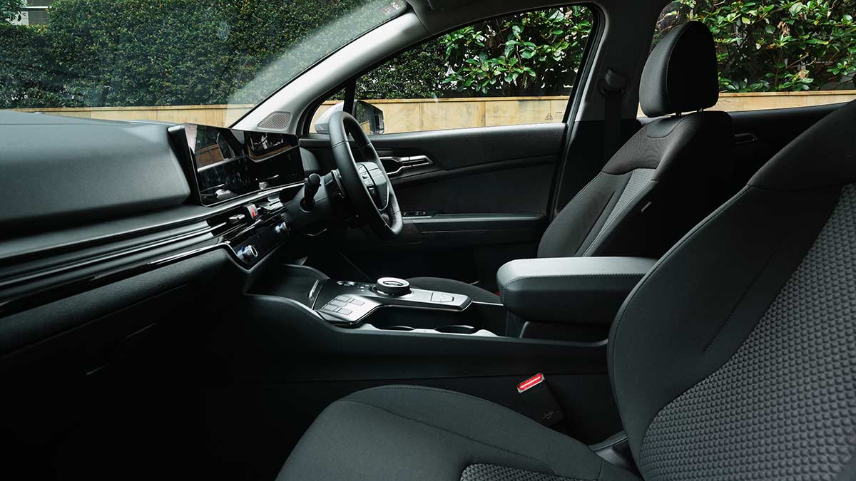 View of driver's seat, steering wheel and dash in 2026 Kia Sportage SX Hybrid SUV