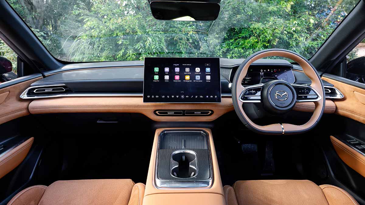 Mazda 6e sedan cockpit area with tan and contrasting dark grey trim and dual digital screens.