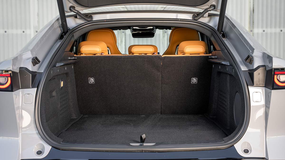 Tailgate of Mazda 6e EV open showing boot area and tan leather seat trim.
