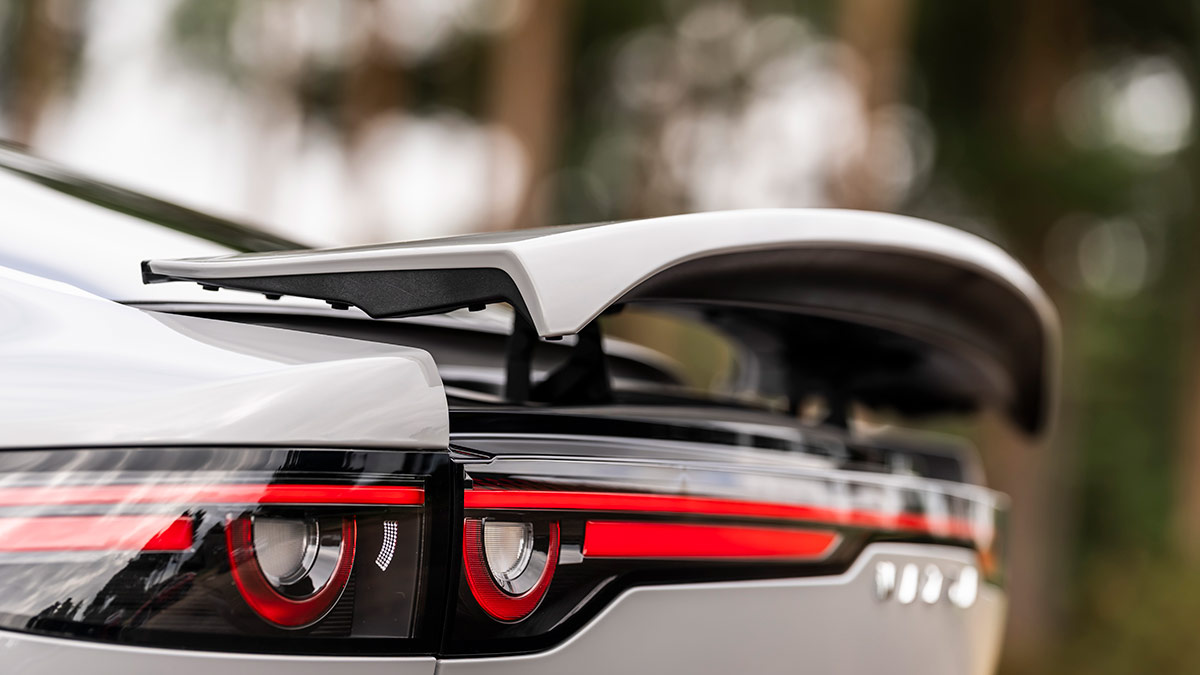 Electric rear spoiler in raised position on Mazda 6e liftback sedan's tailgate.