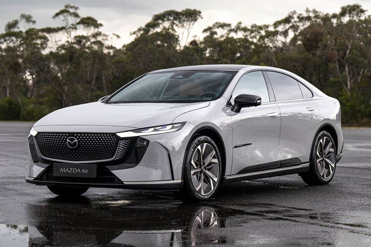 Light grey LHD Euro-spec Mazda 6e sedan on wet bitumen forecourt at Lang Lang proving ground in Victoria.