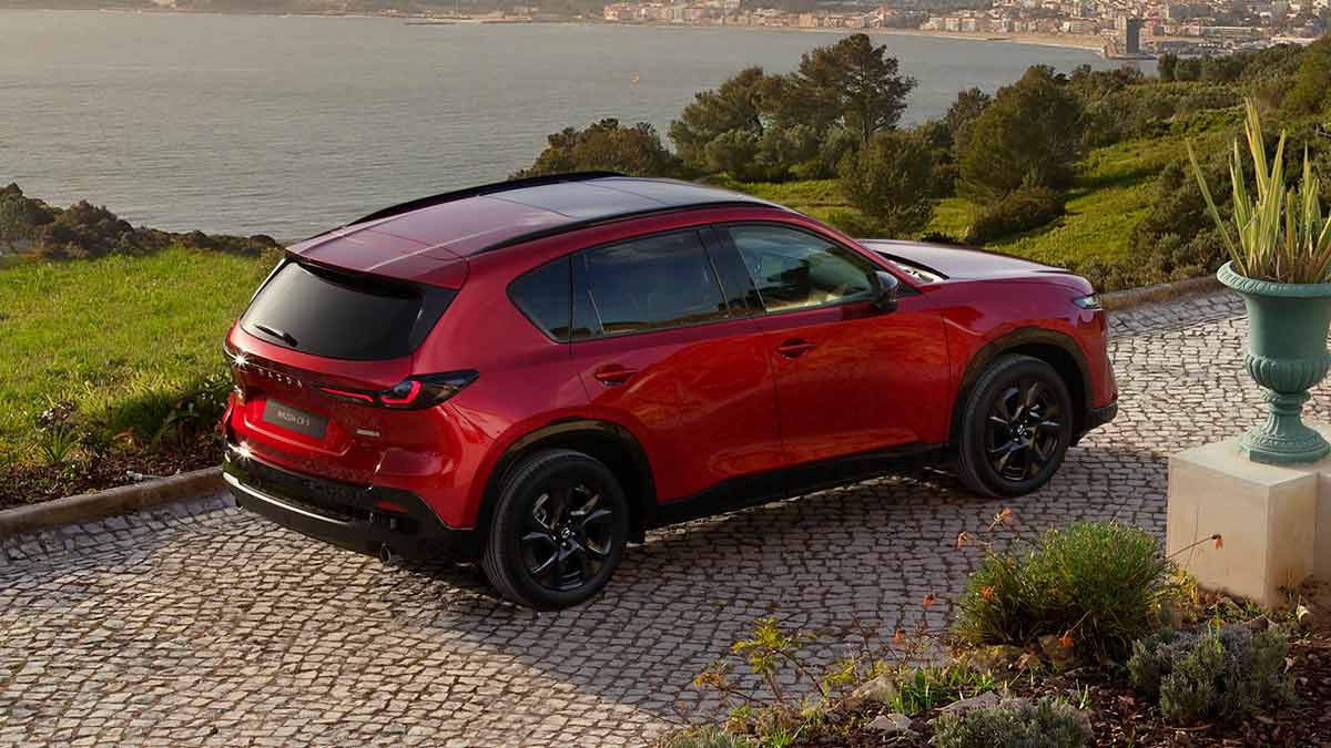 Overhead rear view of red Mazda CX-5 medium SUV at grand seaside location in Europe.