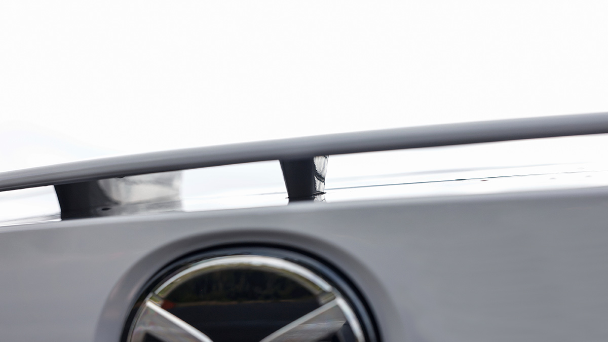 Skyward view of white Mazda CX-6e front end with no grille and aerodynamic vent on bonnet edge.