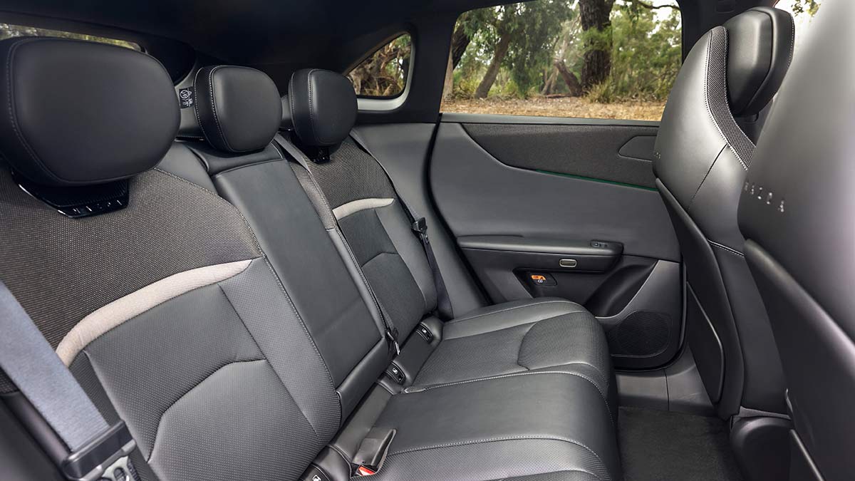 Rear seat area of Mazda CX-6e medium SUV with dark grey synthetic leather trim.