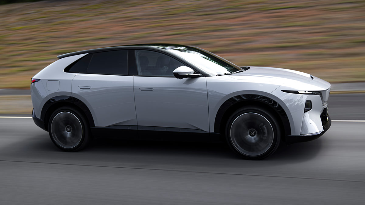 Side view of white LHD Euro-spec Mazda CX-6e SUV driving on ride and handling circuit at Lang Lang proving ground in Victoria.