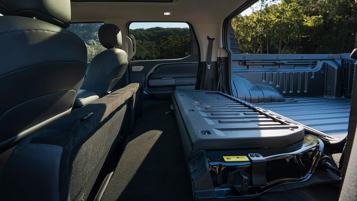 Rear seats folded and bulkhead lowered in MG U9 ute to provide load access from tray to cabin.