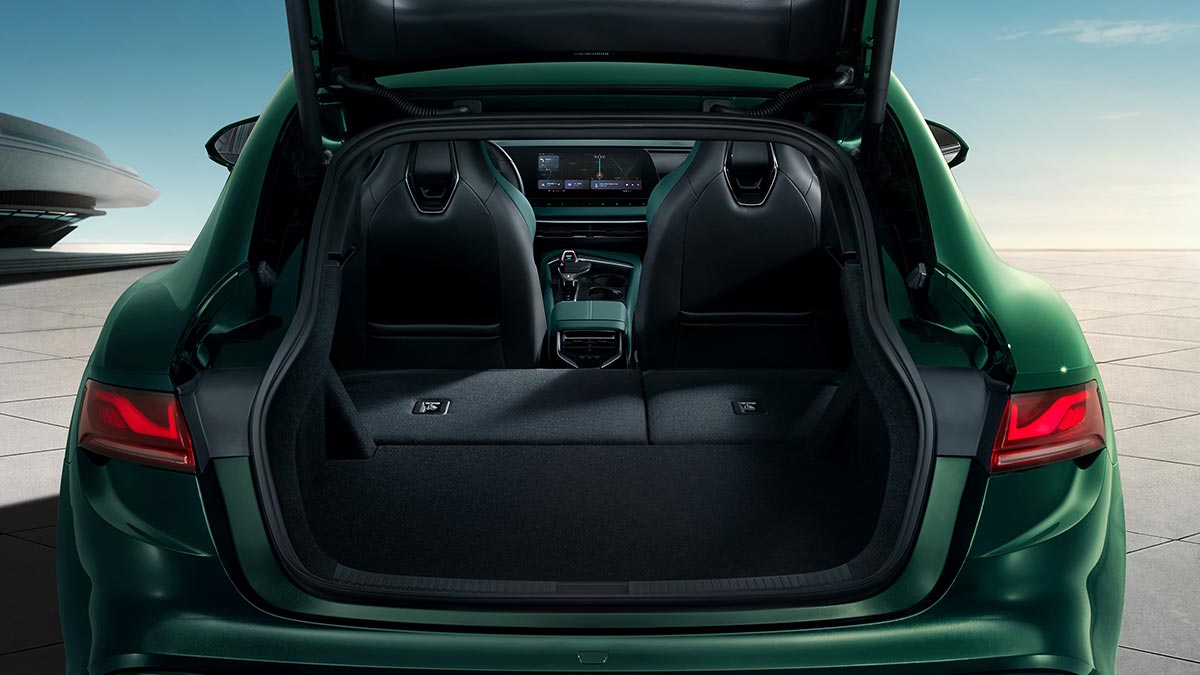 Tailgate open and rear seats folded in cargo area of green MG7 liftback sedan.